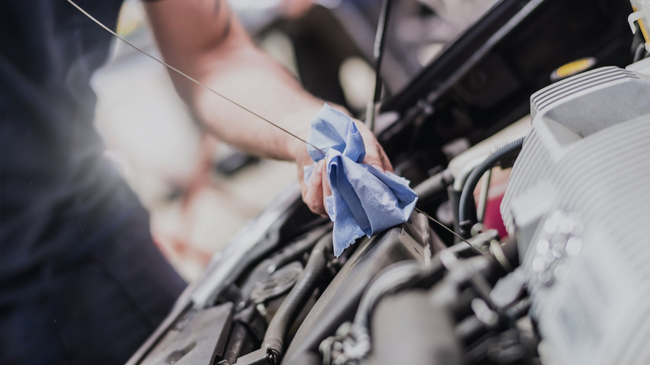 Technician working on bottom of car